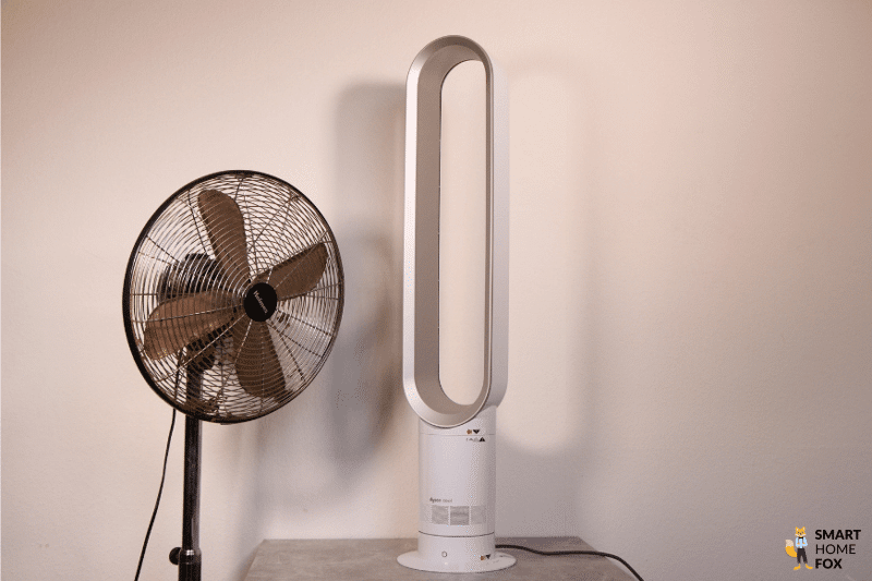 Ein Standventilator steht neben dem Dyson Cool AM07 Turmventilator im Vergleich